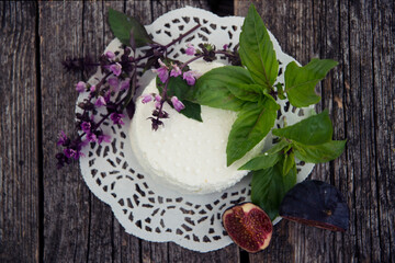 Ricotta cheese, basil and figs on a wooden background.