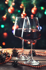 Glasses of wine on the background of a decorated Christmas tree. New Year