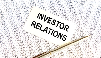 The inscription on the INVESTOR RELATIONS business card. All against the background of reports and pens.