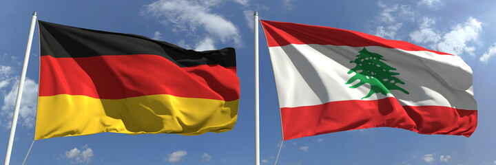 Flying flags of Germany and Lebanon on high flagpoles. 3d rendering
