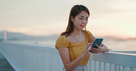 Woman uses mobile phone in evening time