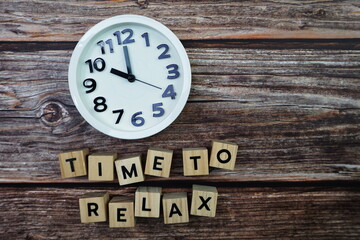 Time To Relax alphabet letter with alarm clock on wooden background