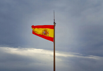 Flying Spanish flag hanging on flagpole