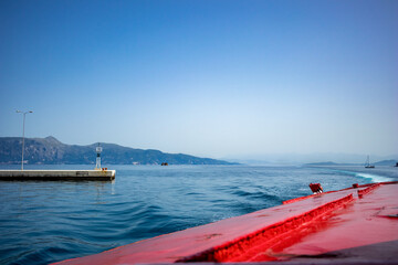 Entering the port of Kerkira. Corfu island, Greece. Classic blue color, mountains and sky in the background. Amazing sea landscape. Beautiful view from the ferry from Saranda, Albania