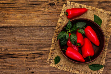 Ripe whole red mini peppers in clay bowl