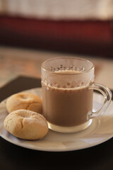 Cookies and coffee in a white plate. Coffee with milk in glass cup. Homemade cookies.