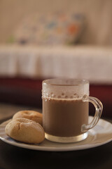 Cookies and coffee in a white plate. Coffee with milk in glass cup. Homemade cookies.