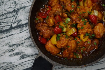 A dishes named Chicken sweet sour on a hot pan over vintage background. usually, people eat with rice.