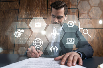 Businessman in office signs contract and business hologram. Double exposure. Formal wear. Concept...