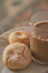 Cookies and coffee in a white plate. Coffee with milk in glass cup. Homemade cookies.