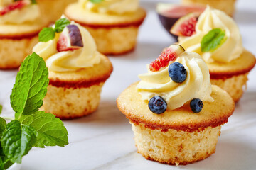 cupcakes with buttercream and berries on a table