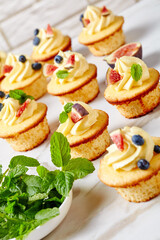 cupcakes with buttercream and berries on a table