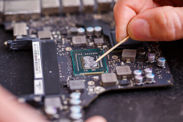 Professional computer and tablet repair shop or service. Close up of a computer board. Electronics concept. Detail from a laptop under repair
