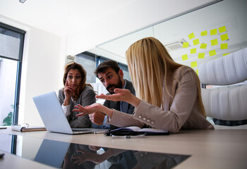 Colleagues sit at a conference table and analyze the business, they are thinking how to solve a problem