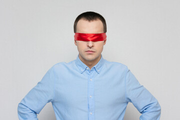 Fototapeta premium Pensive man with a blindfold, red blindfold, portrait, white background, copy space