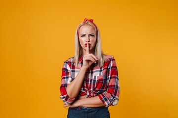 Image of displeased blonde pinup girl showing silence gesture