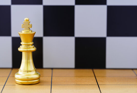 Gold King Chess Piece On Wood Chessboard