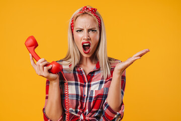 Image of furious pinup girl screaming while posing with handset