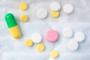 Colorful pills with medicines, white background, close up, top view