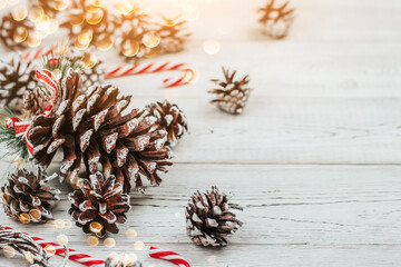 Pine cones and Christmas decor on a white wooden background copy space.
