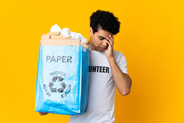 Young Venezuelan man holding a recycling bag full of paper to recycle with headache