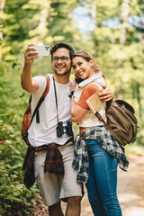 Young couple takes a selfie photo in nature, they look happy and lovely