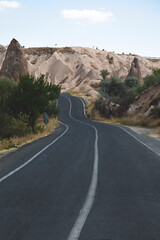 Car travel concept - a road with asphalt among the mountains. Summer trip to Cappadocia, Turkey