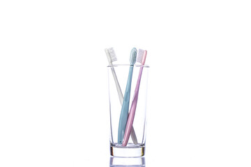 colorful plastic Toothbrushes in glass isolated on white background copy space. Love triangle concept. threesome concept. Brush your teeth every day