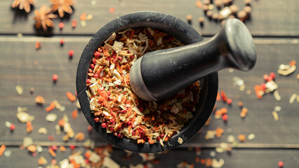 Grinding spices herbs in a mortar with pestle. Top View. - 381621556