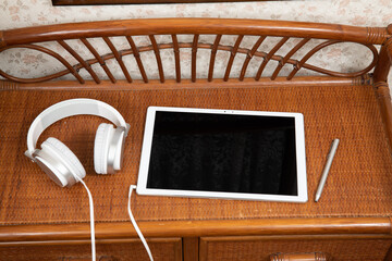 家具の上のタブレットPCとスマートフォンとヘッドフォン