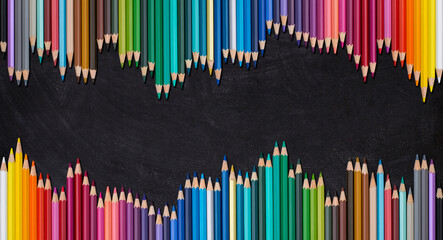 Wave border of colorful wooden pencils on a blank blackboard, back to school concept.