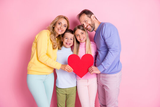Photo of positive loving comfort family mom dad little girl boy hold red paper card heart isolated on pastel color background