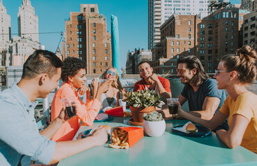 Group of friends apending time together on a rooftop in New york city, lifestyle concept with happy...