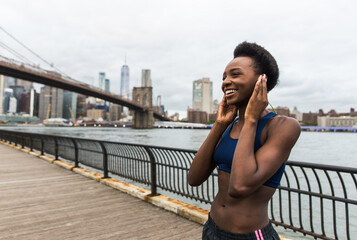 Athlete woman training in the morning at sunrise in New york city, Brooklyn in the background