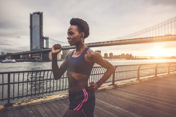 Athlete woman training in the morning at sunrise in New york city, Brooklyn in the background