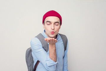 In love teen in love sends a air kiss, white background, portrait