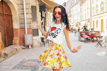 young beautiful woman walking in old city street, summer Europe vacation, travel, fun, happy, smiling, sunglasses