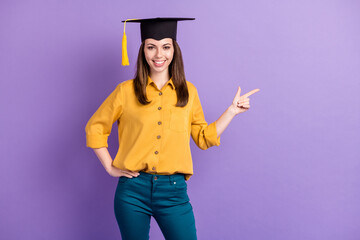 Photo of cute lady direct fingers empty space look camera wear yellow shirt blue pants college cap...