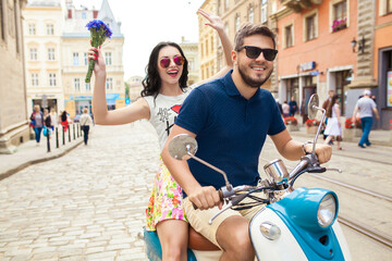 young beautiful hipster couple riding on motorbike city street, summer europe vacation, traveling, romance, smiling, happy, having fun, sunglasses, stylish outfit, together in love, adventures, date