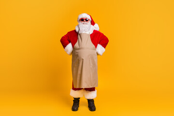 Fototapeta na wymiar Full body photo of santa grandpa grey hair wait customers clients take order own business cafe entrepreneur wear red costume coat gloves sun specs cap apron isolated yellow color background