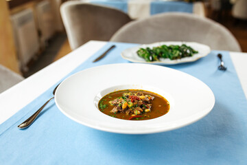 Spanish traditional oxtail soup in white plate