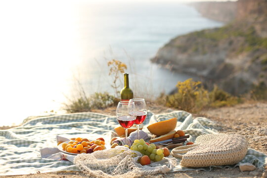 picknick outdoors with fruits and wine by sea in naure