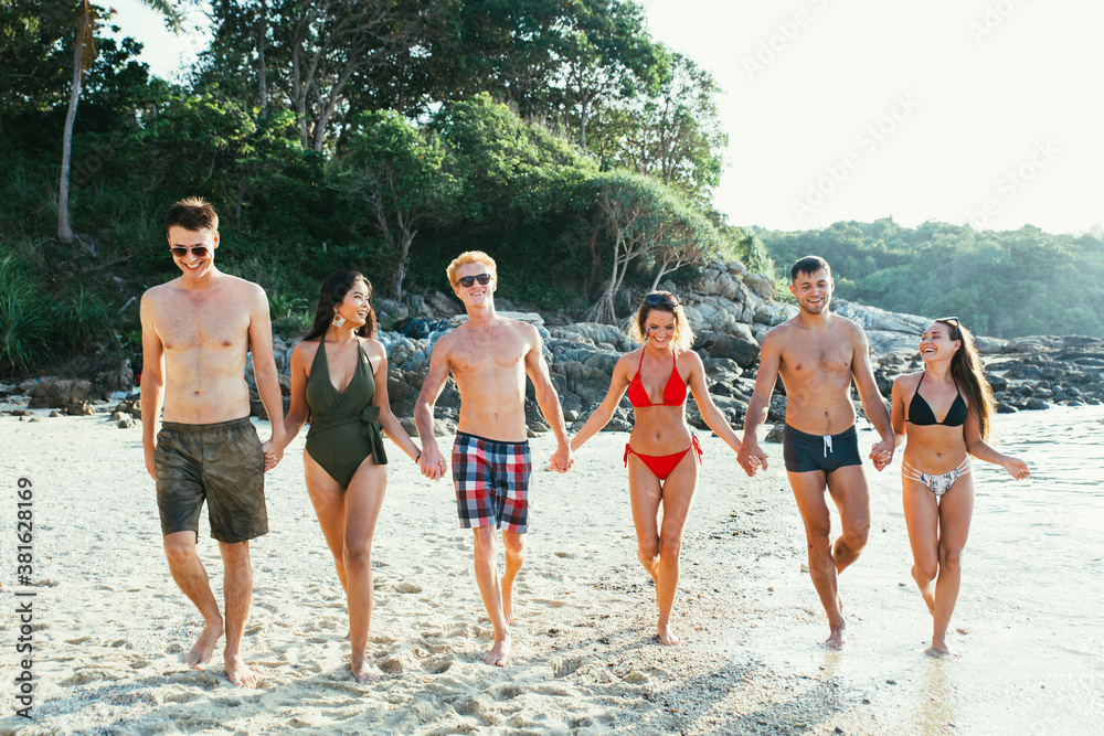 Wall mural group of friends having fun on the beach on a lonely island