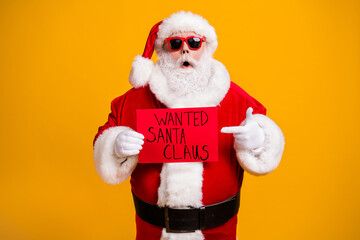 Portrait of his he nice attractive fat overweight amazed stunned Santa holding in hand demonstrating red board wanted isolated over bright vivid shine vibrant yellow color background