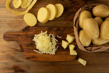 Raw Grated Potato on Wooden Cutting Board Background