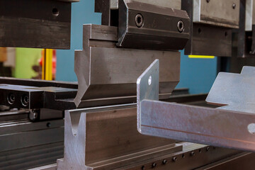 Bending sheet metal on a hydraulic machine at the factory. Bend tools, press brake punch and die....