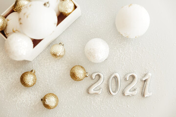 Fototapeta na wymiar Happy New Year 2021. Silver digits 2021 with christmas hat are on white background. Holiday Party Decoration or postcard concept with top view and copy space