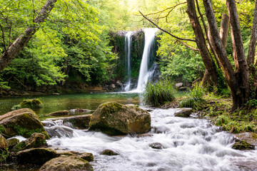 Beautiful waterfall with a river and a pond in a magical and idyllic scenery. Gorg de Santa Margarida, Planes d'Hostoles, Olot, Garrotxa, Girona, Catalonia, Spain.