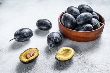 Fresh organic bio plums in a bowl. White background. Top view. Copy space