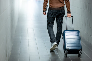 Travel insurance concept. Male tourist carrying suitcase luggage and digital tablet walking in...